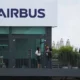 Airbus building exterior with people on balcony.