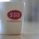 White mug with SBB logo on table