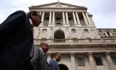 Bank of England with three people outside.