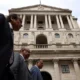 Bank of England with three people outside.