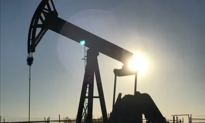 Oil pumpjack silhouetted against setting sun