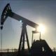 Oil pumpjack silhouetted against setting sun