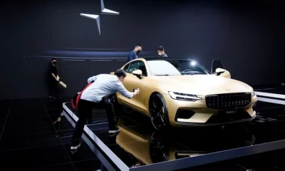 People polishing a luxury car at an event.