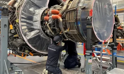 Engineers inspecting aircraft engine in workshop