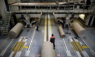 Workers operating large paper production machinery