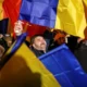 People holding Romanian flags at a gathering