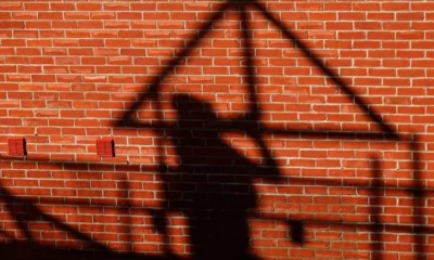 Shadow of worker on brick wall during construction.