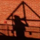 Shadow of worker on brick wall during construction.