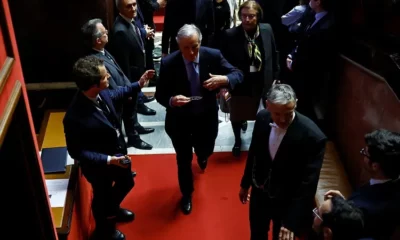 Group of people in formal attire on red carpet.