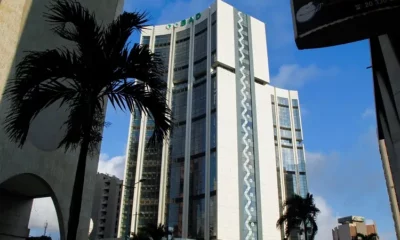 Modern skyscraper in urban cityscape under blue sky.