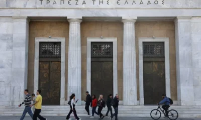 People walk past Bank of Greece building.