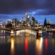 Frankfurt skyline at night with illuminated bridge