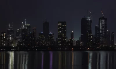 City skyline illuminated at night over water reflection.