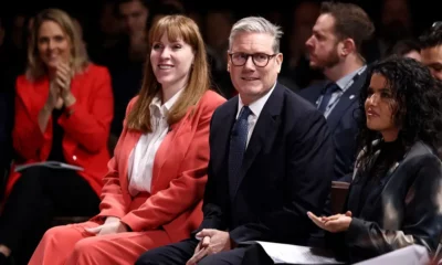 People attending conference, smiling and clapping.