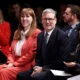 People attending conference, smiling and clapping.