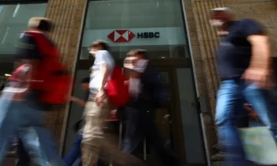 People walking past HSBC bank entrance.