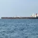 Large tanker ship on open sea horizon.