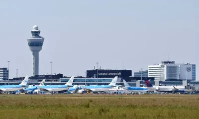 Schiphol Airport control tower and parked airplanes