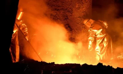 Workers in protective gear at a steel factory.