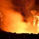 Workers in protective gear at a steel factory.