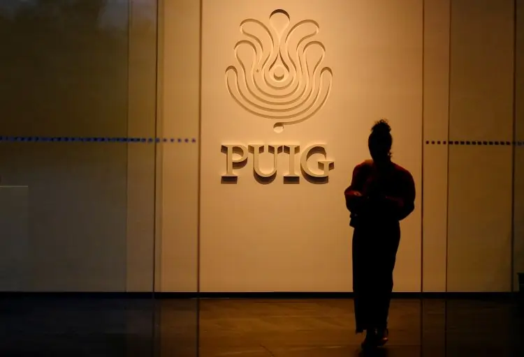 Silhouette in front of Puig company logo.