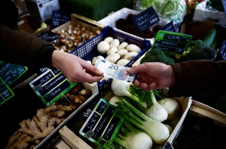 Exchanging money at a vegetable market stall.