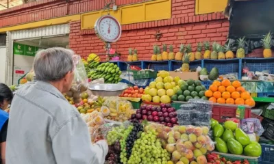 Person shopping at vibrant fruit market stall.