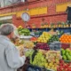 Person shopping at vibrant fruit market stall.