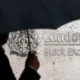 Silhouette with umbrella at London Stock Exchange entrance.