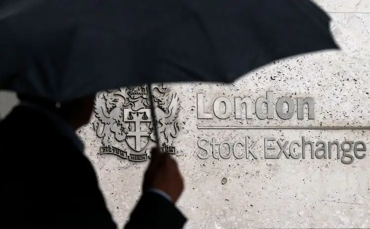 Silhouette with umbrella at London Stock Exchange entrance.