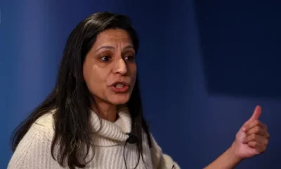 Woman giving a speech, gesturing with hand.