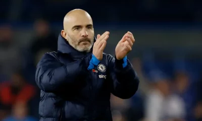 Football coach applauding on the sidelines.