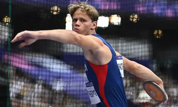 Athlete in blue prepares to throw a discus.