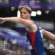 Athlete in blue prepares to throw a discus.