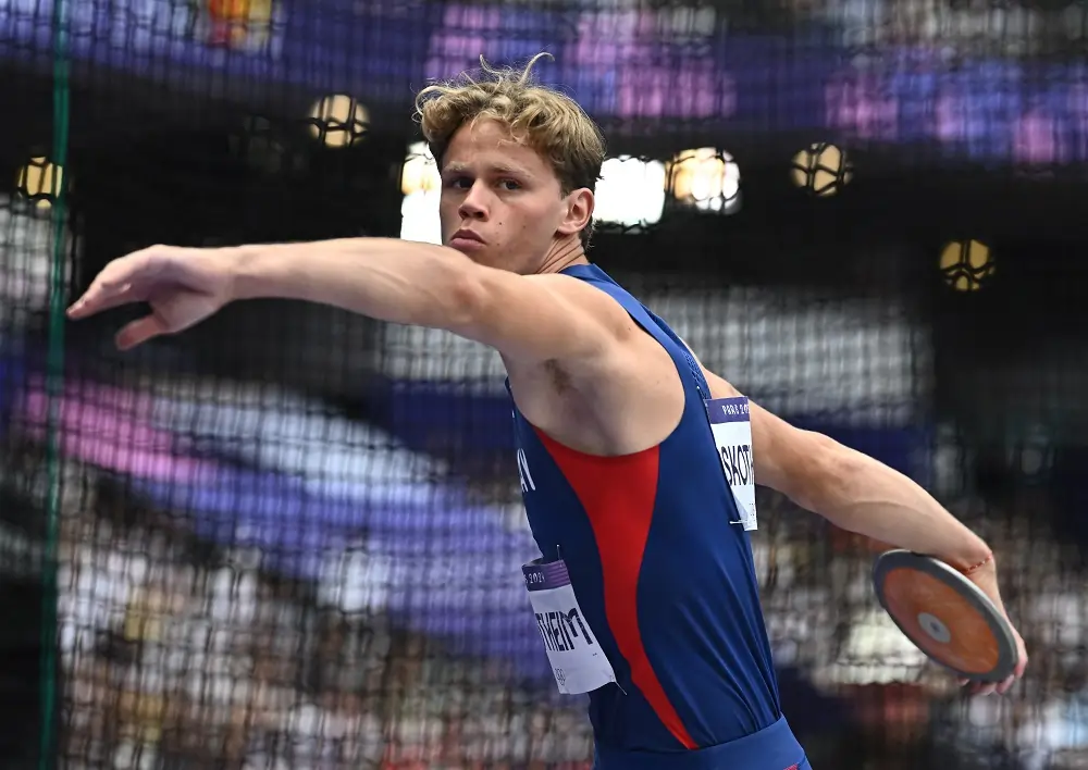 Athlete in blue prepares to throw a discus.