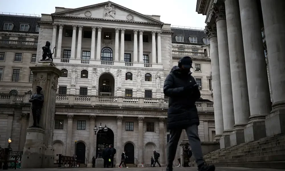 Person walks past historic building in winter attire.