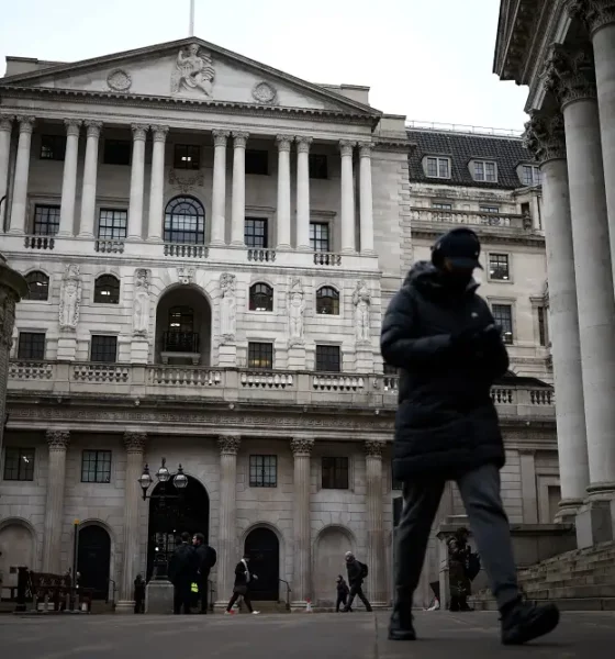 Person walks past historic building in winter attire.