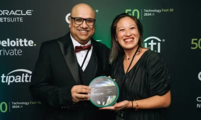 Two people holding an award, smiling.