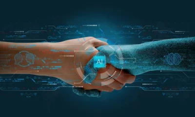 Human and robot handshake representing AI collaboration.