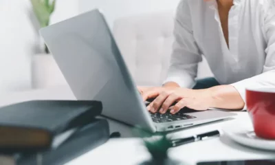 Person typing on a laptop in office.