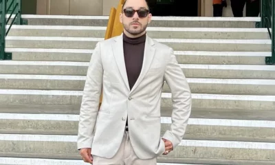 Man in suit on steps with sunglasses.