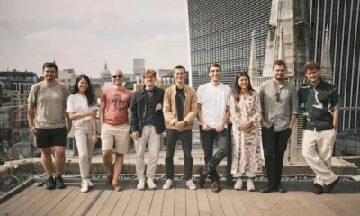 Group of people on rooftop with cityscape background.