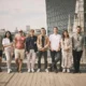 Group of people on rooftop with cityscape background.